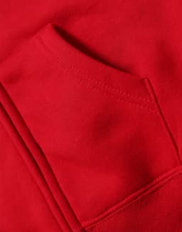 A close-up of a red full-zip fleecy hoodie featuring a front pocket. The fabric appears soft and cozy.