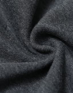 A close-up of dark grey fabric showcasing a soft, fleecy texture with a slight swirl pattern.