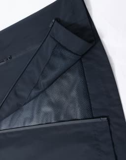 A waterproof jacket in navy, featuring zippered pockets and mesh lining. It includes a logo.