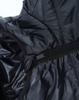 A close-up of a lightweight hooded puffer jacket in black, showcasing its zipper and inner lining.