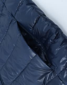 A navy blue lightweight puffer jacket featuring a zippered pocket and a hood, with a glossy finish.