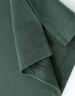 A close-up of a ladies cotton stretch polo shirt in dark green, showing the cuff and stitching details.