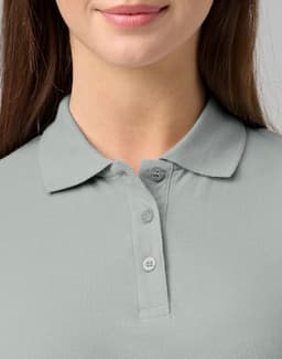 A close-up of a woman's light grey cotton stretch polo shirt with a collared neck and three buttons.