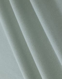 A close-up of light green cotton fabric, featuring a textured weave suitable for polo shirts.