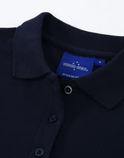 A navy ladies cotton stretch polo shirt featuring a classic collar and buttons, with a logo label inside.