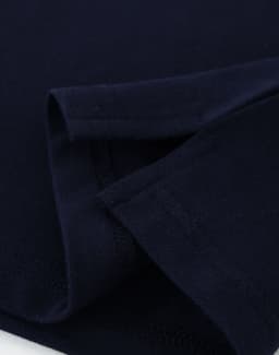 A navy ladies cotton stretch polo shirt, featuring folded sleeves and a smooth fabric texture. It has a logo.