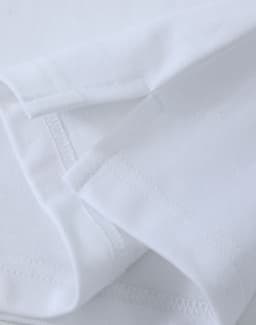 A close-up of a white cotton stretch polo shirt, featuring stitched hem and sleeve details. It has a logo.
