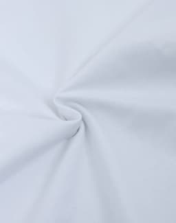 A close-up of white fabric, showcasing its heavy cotton texture and smooth surface. The fabric is gathered in a swirl.