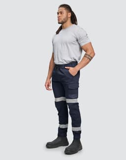 Cotton stretch drill cuffed work pants in navy blue with reflective tape details, worn by a standing male model.