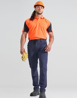 A worker models DWR water repellent flexi work pants in navy, paired with an orange shirt and safety gear.