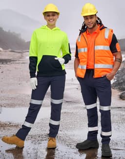 A woman in a high-vis yellow and navy hoodie and a man in an orange vest wear navy pants with reflective tapes.