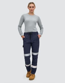 Navy blue work pants with reflective tape, featuring pockets and a comfortable fit, modelled by a woman.