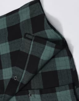 A unisex flannel plaid shirt featuring green and black checks, with buttons and a small pocket detail.
