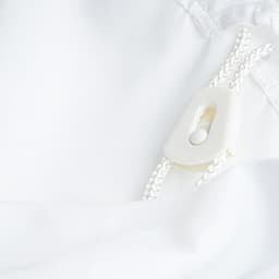 A white laundry bag made of 100% polyester, featuring a drawstring closure with a plastic toggle.