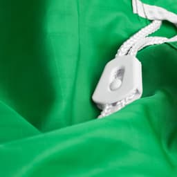 A green laundry bag made of 100% polyester featuring a white drawstring closure mechanism.