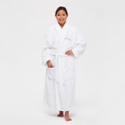 A white deluxe microfibre robe with a belt, featuring pockets and a soft texture. The model stands smiling.