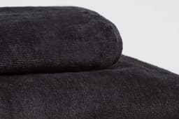 Two black sports towels stacked on top of each other, featuring a textured surface and a logo.