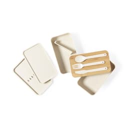 A collection of beige lunch box compartments and utensils, including a bamboo tray with a spoon, fork, and knife.