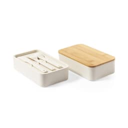 A lunch box in cream with a wooden lid, featuring utensils inside. It also has a logo printed on it.