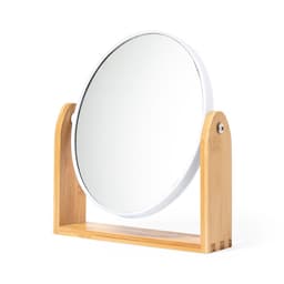A round mirror with a white frame, supported by a natural bamboo stand.