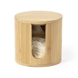 A cylindrical bamboo container with a cut-out section, revealing a white mesh item inside. It has a smooth, natural finish.