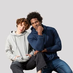 A grey hoodie and a navy hoodie worn by a man and a woman, both smiling while sitting together.