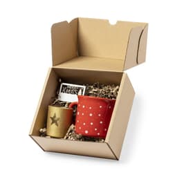 A red mug with white stars and a gold cup with a star, packaged in a cardboard gift box with filler.