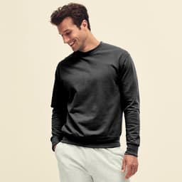 A man wearing a black lightweight set-in hoodie, paired with light grey pants, smiling while looking down.