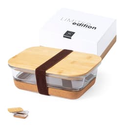 A glass lunch box with a bamboo lid and a cork base, secured with a brown elastic strap, packaged in a box.