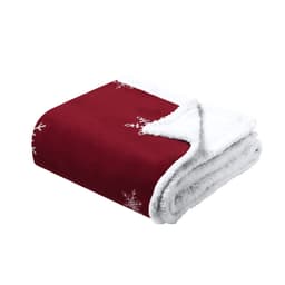 A red blanket with white snowflake patterns and a fluffy white lining, featuring a logo.