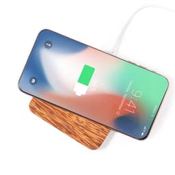 A wireless charger with a wooden base and a smartphone displaying a charging battery icon.