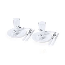 A picnic set featuring two white plates, glasses, forks, knives, and salt shakers, neatly arranged.