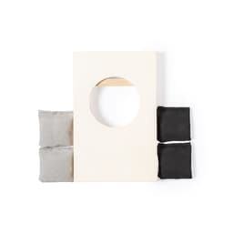A game set featuring a rectangular board with a circular hole and four bean bags in grey and black.