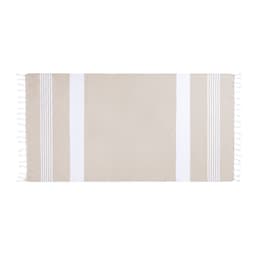 A beige bath towel with white stripes and tassels, featuring a logo on one side.