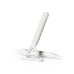 A shaving kit featuring a white razor with a textured handle and a tube of shaving cream.