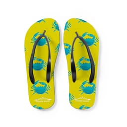 A pair of bright yellow thongs featuring a crab pattern and black straps. The design has a logo at the bottom.