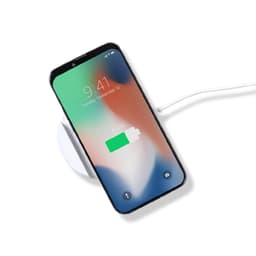A wireless charger holder in white with a smartphone displaying a charging battery icon. The charger has a cable connected.