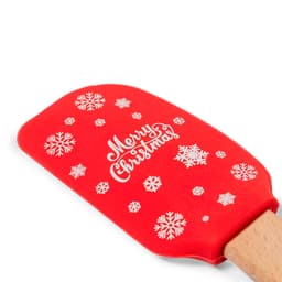 A red spatula featuring white snowflakes and the phrase "Merry Christmas." It has a wooden handle and a logo.