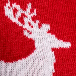 A red scarf featuring a white knitted reindeer design, with a soft texture and festive pattern.