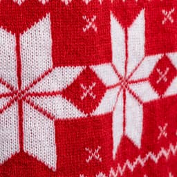 A red and white knitted scarf featuring a snowflake pattern and geometric designs. It has a decorative knitted texture.