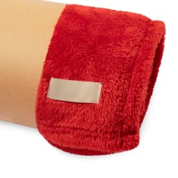 A plush red blanket featuring a soft texture and a branding tag on the side.
