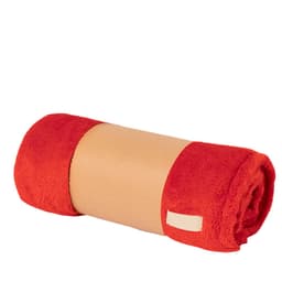 A rolled-up blanket in vibrant red with a neutral band around the centre. It features a branding label.