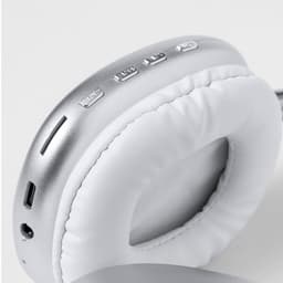 Wireless headphones in silver and white featuring buttons and a charging port on the ear cup.