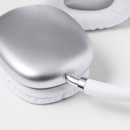 A silver headphone with white ear cushions and a connector, featuring a sleek, modern design.