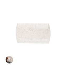 A pet grooming comb in a light colour with fine and wide teeth. Features a logo on the handle.