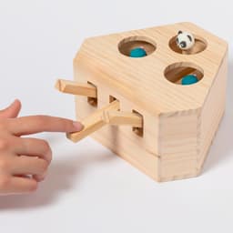 A wooden game with four holes, featuring blue balls and a panda figure, and two levers on the sides.