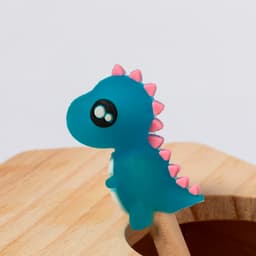 A teal dinosaur figurine with pink spikes, perched on a wooden surface. Features a glossy finish and big eyes.