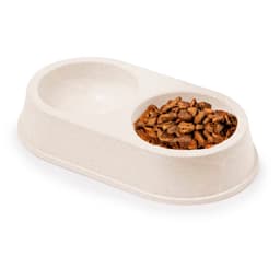 A beige pet food and water bowl with a divided design, featuring one side filled with dry pet food.
