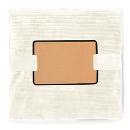 A soft, cream-coloured blanket with a smooth texture and a logo patch in the centre. It is neatly folded and secured with straps.