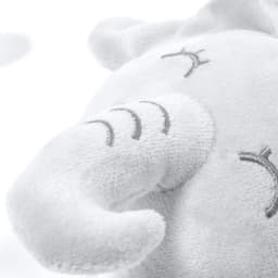 A plush toy elephant in soft white fabric with embroidered facial features and a curled trunk.